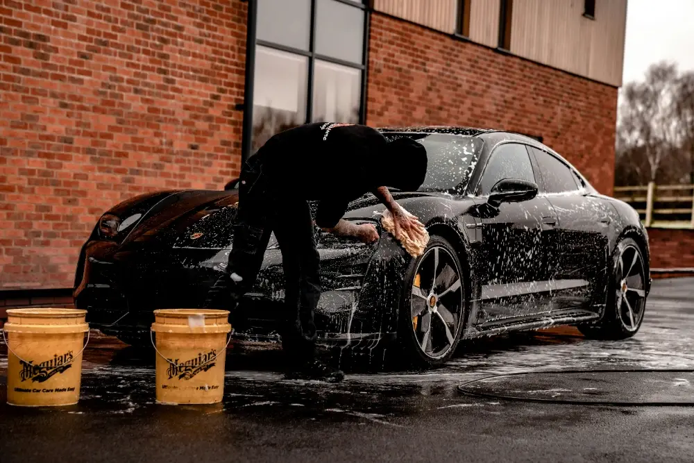 Detailer hand-washing and foaming down a car in Bend, Oregon